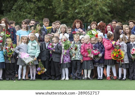 ST. PETERSBURG, RUSSIA - SEP, 1, 2014: School line is in schoolyard with first-grade pupils and teacher. Children go back to school at first time in September