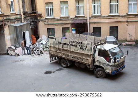 ST. PETERSBURG, RUSSIA - CIRCA JUN, 2015: People load construction debris in small lorry body. Recycling of construction waste during a new interior finishing