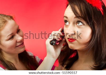 Stylist make image of contemporary model in photographic studio. Two young women. Facial portrait.