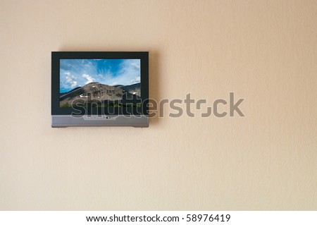 Liquid-crystal television receiver on wall. Picture on screen (I have rights on it). Copy space
