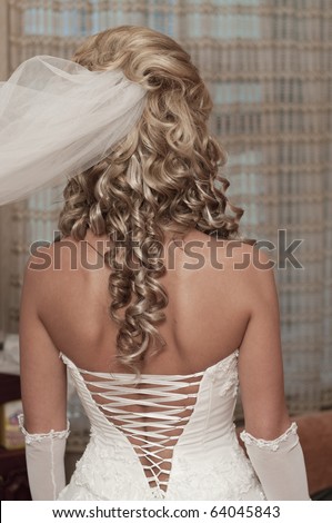 The back of beautiful young bride with a white corset wedding dress