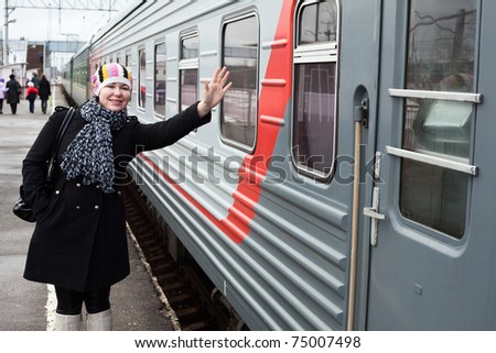 Girl says goodbye departing train and waves by hand after him