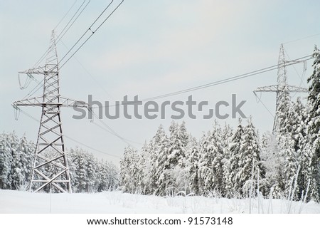 High-voltage electric lines laid on the snowy evergreen northern woods in Russia