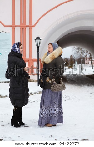 Russian women in winter clothes against Orthodox monastery