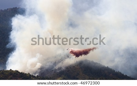 Small airplane dropping fire retardant on forest fire in Colorado