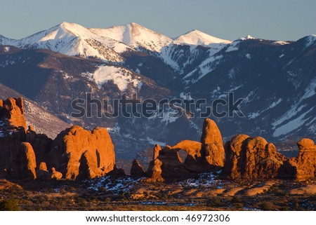 Rock formations in morning sunlight with Manti La Sal mountains in background, Arches N.P., Utah