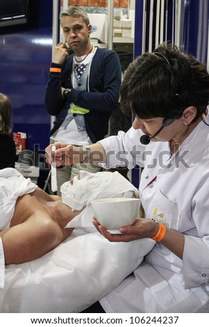 MOSCOW-APRIL 19: Cosmetician doing cosmetic mask at the international exhibition of professional cosmetics and beauty salon equipment INTERCHARM on April 19, 2012 in Moscow