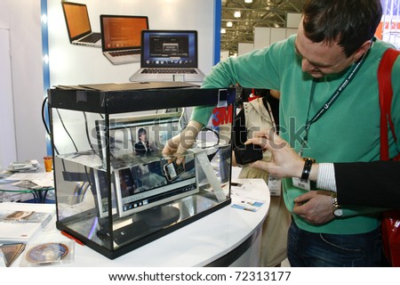 MOSCOW - FEBRUARY 16: Cell phone in water tank presented at the International Exhibition Security and Safety Technologies February 16, 2011 in Moscow.