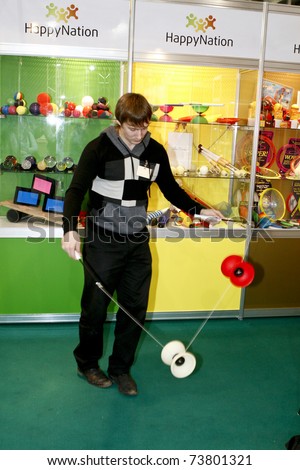 MOSCOW - MARCH 16: A guy plays with a yo-yo presented at the International Specialized Exhibition the Toy Russia March 16, 2011 in Moscow