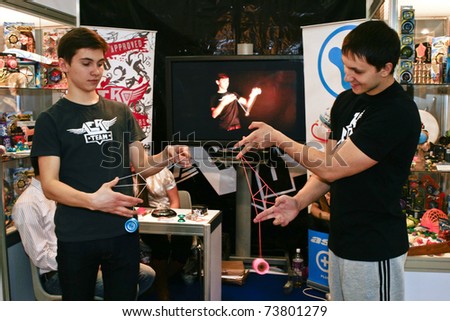 MOSCOW - MARCH 16: Two guys play with a yo-yo presented at the International Specialized Exhibition the Toy Russia March 16, 2011 in Moscow