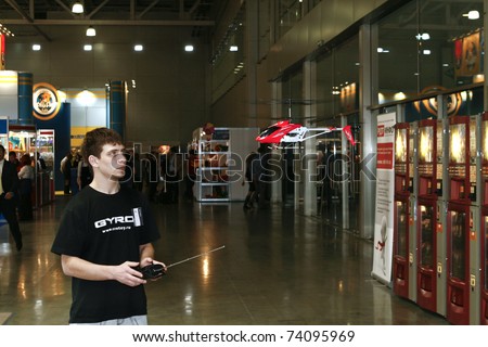 MOSCOW - MARCH 16: Mini RC helicopter toy against the man face presented at the International Toy Specialized Exhibition March 16, 2011 in Moscow