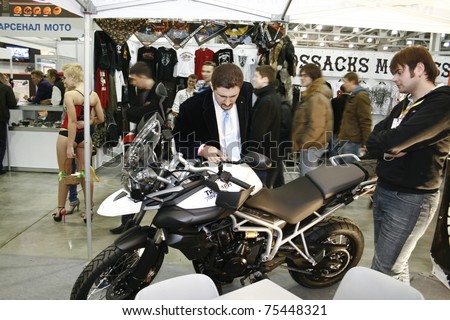 MOSCOW - APRIL 1: Man consults a motorcycle Triumph Tiger at the Moscow specialized Exhibition  of motor cycling industry in Russia on April 1, 2011 in Moscow, Russia
