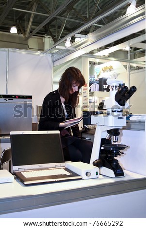 MOSCOW - APRIL 28: Unidentified girl reads instruction microscope at the international exhibition of analytical and laboratory equipment in Russia and CIS on April 28, 2011 in Moscow, Russia.
