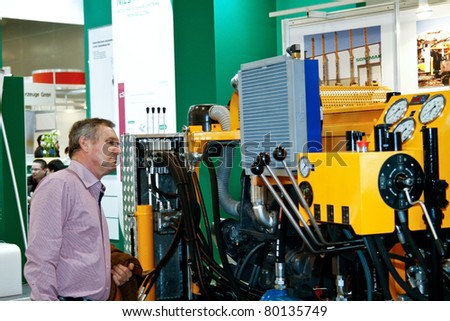 MOSCOW - APRIL 13: Man interested drilling machine at the international exhibition of  the Mining and Processing of Metals and Minerals, MiningWorld on April 13, 2011 in Moscow