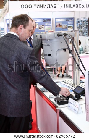MOSCOW - MAY 19: Man shows Gyro-stabilized airborne camera systems at the international exhibition of  the helicopter industry, HeliRussia on May 19, 2011 in Moscow