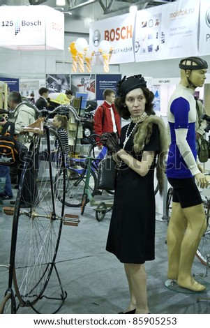 MOSCOW - SEPTEMBER 16: Woman in vintage clothing and vintage bicycle at the international exhibition of the technical antiques on September 16, 2011 in Moscow, Russia