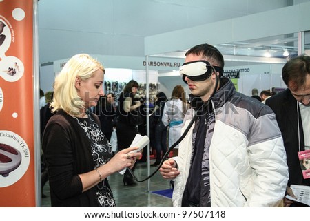 MOSCOW - OCTOBER 26: Man use magnetic eye massager at the international exhibition of professional cosmetics and beauty salon equipment INTERCHARM on October 26, 2011 in Moscow
