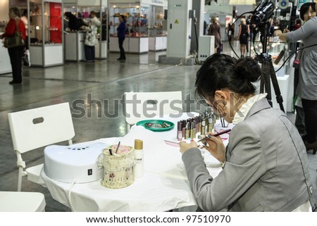 MOSCOW - OCTOBER 26: Master make nail extension at the international exhibition of professional cosmetics and beauty salon equipment INTERCHARM on October 26, 2011 in Moscow