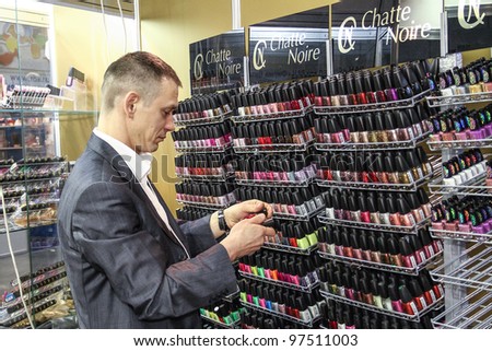 MOSCOW - OCTOBER 26: Man chooses makeup at the international exhibition of professional cosmetics and beauty salon equipment INTERCHARM on October 26, 2011 in Moscow