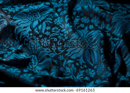 folds of black-and-blue cashmere cloth (beautiful and smooth cashmere background with floral pattern)