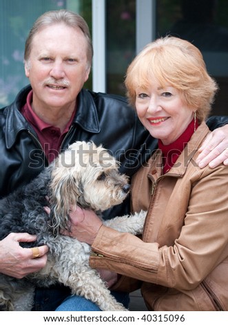 Happy retired couple embracing one another retired couple sitting with their dog
