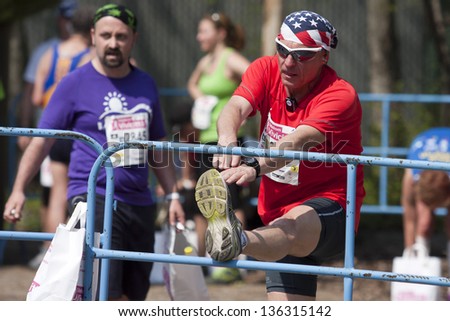 BUDAPEST, HUNGARY - APRIL 21: unidentified marathon runner stretches to cool-down at 28th Telekom VivicittÃ?Â¡ Pro City Run on April 21, 2013 in Budapest, Hungary