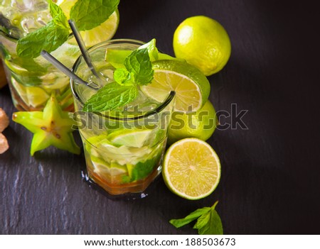 Summer lime cocktails , drink with fresh fruits on balck stone.
