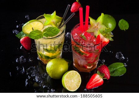 Summer strawberry and lime cocktails , drink with fresh fruits on black stone.