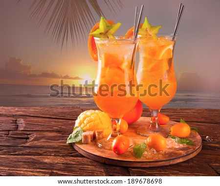 Summer orange cockatails with fresh fruits on wooden background. Tropical beach.