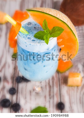 Summer cocktail , drink with fresh fruits on wooden table and tropical beach. Blue sky, sea
