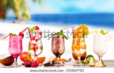 Summer drinks with blur, tropical beach on wooden table