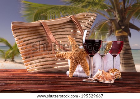 Summer concept, white nad red wine on tropical beach. straw hat, candle Blue sky, sea