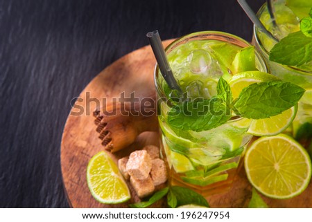 Lime summer mojito drink on black stone, table