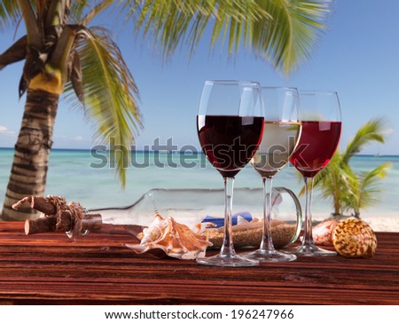Summer concept, white nad red wine on tropical beach.Blue sky, sea