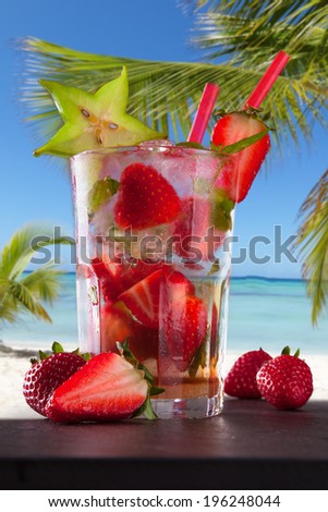 Strawberry summer mojito drink on tropical beach.