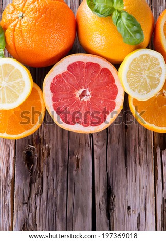 Fresh grapefruit, orange and lemon with slices on a wooden table. Wood background.