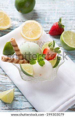 Ice Cream lime and strawberry, summer sundae with fresh fruits on wooden background.
