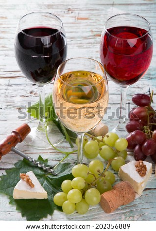 Wine and cheese on wooden table with fresh grapes