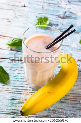 Fresh milk, banana on wooden table, assorted protein cocktails with fresh fruits. Natural background.