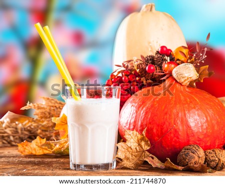 Fresh milk shake, autumn leaves with season vegetable on wooden table