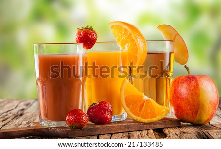 Fresh juice, mix fruits, strawberry, orange and apple drinks with nature green background