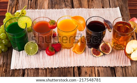 Fresh fruits juices on wood plant, strawberry, orange, lime, ficus and apple drinks