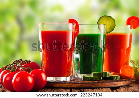 fresh juice, mix vegetable, tomato, cucumber and carrot drinks with nature green background.