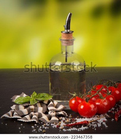 Pasta spaghetti, vegetables and spices, on wooden table, on balck stone  background