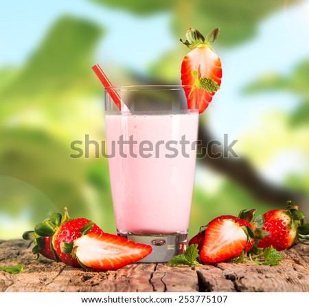 Fresh milk, strawberry drink on wooden table, assorted protein cocktail with fresh fruits and nature green background.