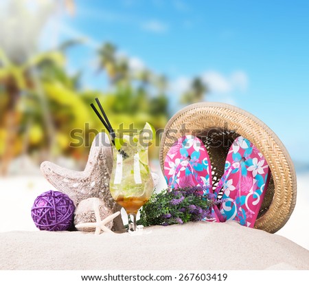 Mojito drink, straw Hat, sunglasses and flip-flops with tropical beach background, summer accessories