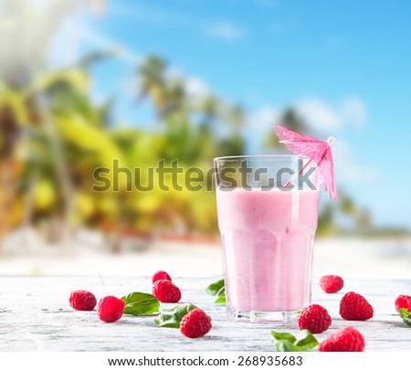 Fresh milk, raspberry drink on wooden table, assorted protein cocktails with fresh fruits. Tropical beach background.