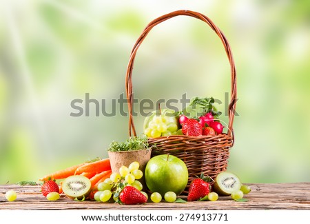 Garden concept, fresh fruits and vegetables on wooden table, watering can, seeds, plants