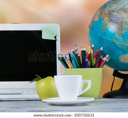 Globe, notebook stack, apple and pencils on wooden table. Back to school concept.