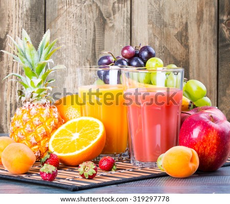 Fresh juice, orange and strawberry with fresh mix fruits on wooden table